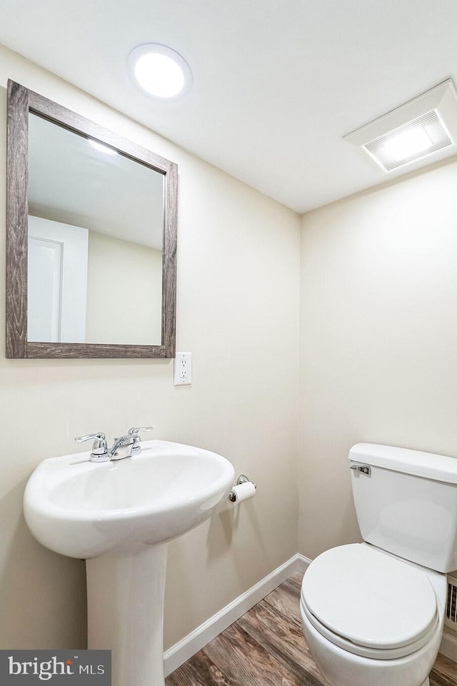 bathroom with hardwood / wood-style flooring and toilet