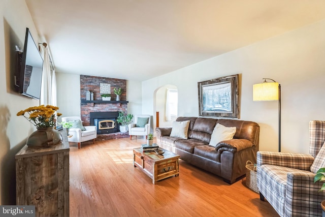 living room with hardwood / wood-style flooring and a brick fireplace