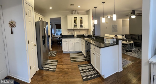 kitchen featuring stainless steel refrigerator with ice dispenser, visible vents, glass insert cabinets, a sink, and a peninsula