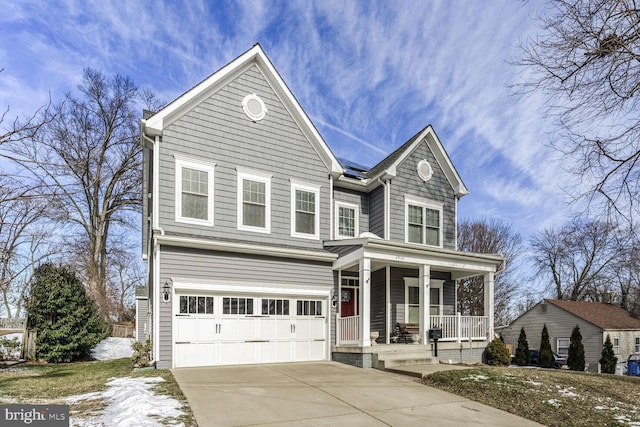 traditional-style house with covered porch, concrete driveway, and an attached garage