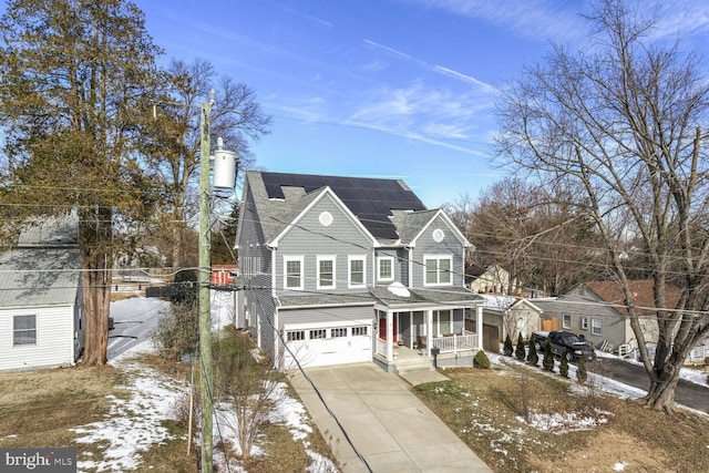 traditional-style home with solar panels, a shingled roof, covered porch, a garage, and driveway