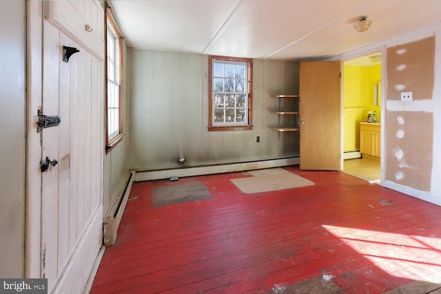 unfurnished room featuring hardwood / wood-style flooring and baseboard heating