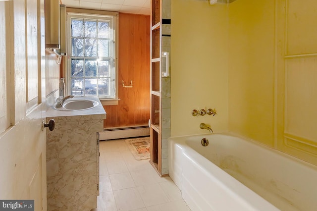 bathroom featuring vanity, wood walls, baseboard heating, and shower / tub combination