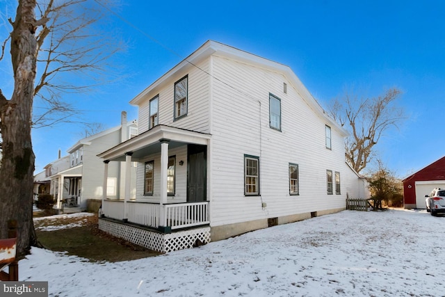 view of snowy exterior featuring a porch