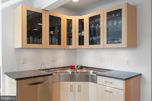 kitchen featuring sink, stainless steel dishwasher, light brown cabinetry, and dark stone counters