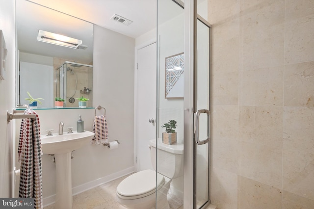 bathroom featuring tile patterned floors, toilet, and walk in shower