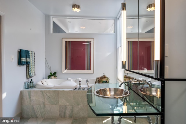 bathroom with dual sinks and tiled tub