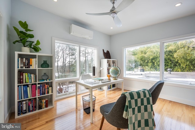 sitting room with a wealth of natural light, a wall mounted air conditioner, ceiling fan, and light wood-type flooring