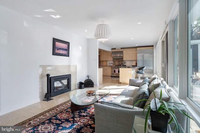 living room featuring a premium fireplace and light tile patterned flooring