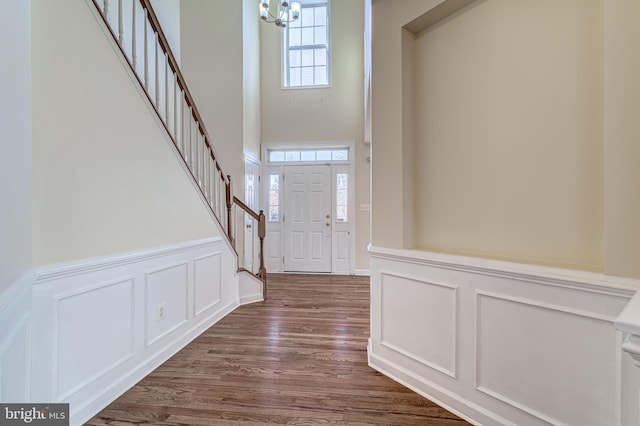 entrance foyer with dark wood-type flooring, an inviting chandelier, and a high ceiling