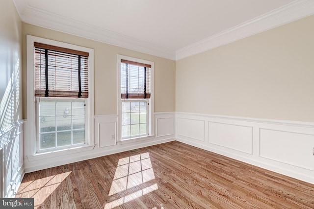 spare room featuring ornamental molding and light hardwood / wood-style flooring