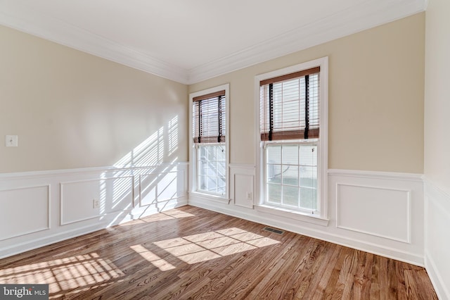 spare room with crown molding and light wood-type flooring