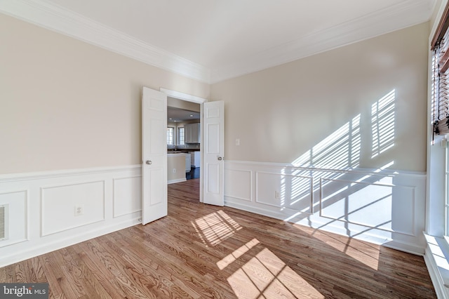 empty room featuring hardwood / wood-style floors and ornamental molding