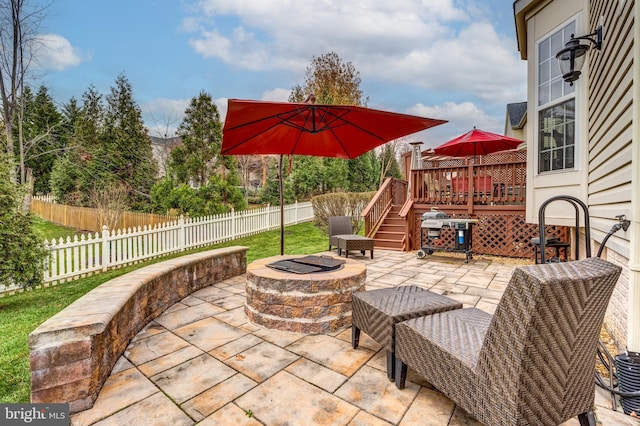 view of patio with area for grilling, a deck, and an outdoor fire pit