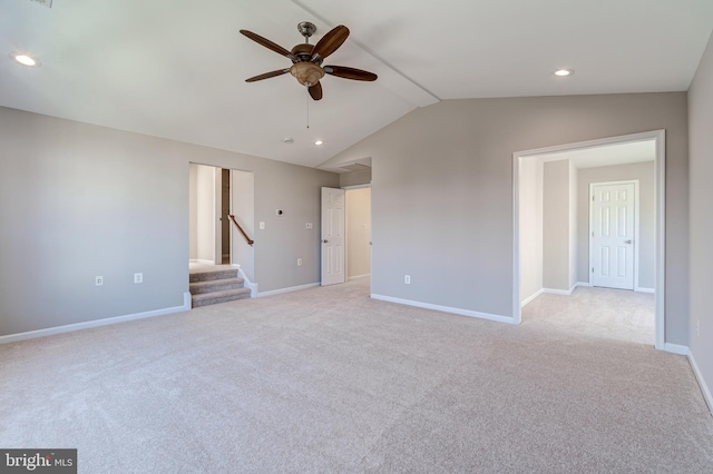 empty room with lofted ceiling, light carpet, and ceiling fan