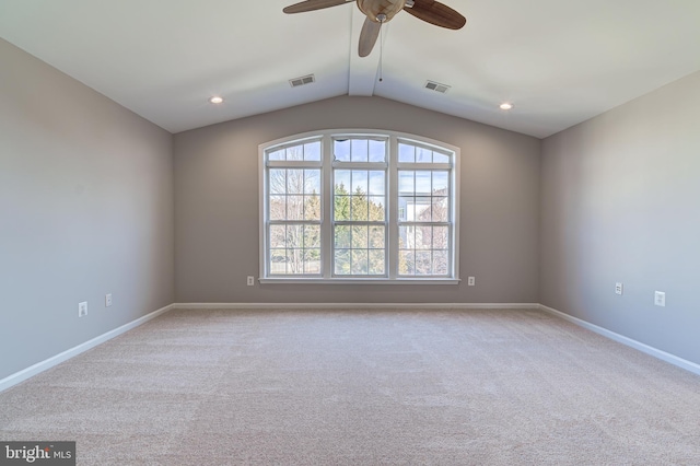 carpeted spare room featuring lofted ceiling, a healthy amount of sunlight, and ceiling fan