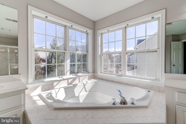 bathroom featuring vanity and tiled tub