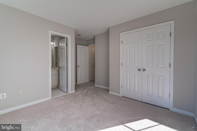 unfurnished bedroom featuring light carpet, connected bathroom, and a closet