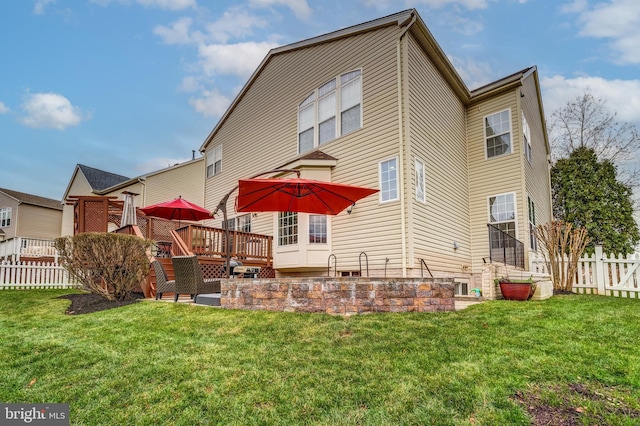 rear view of house with a yard and a deck