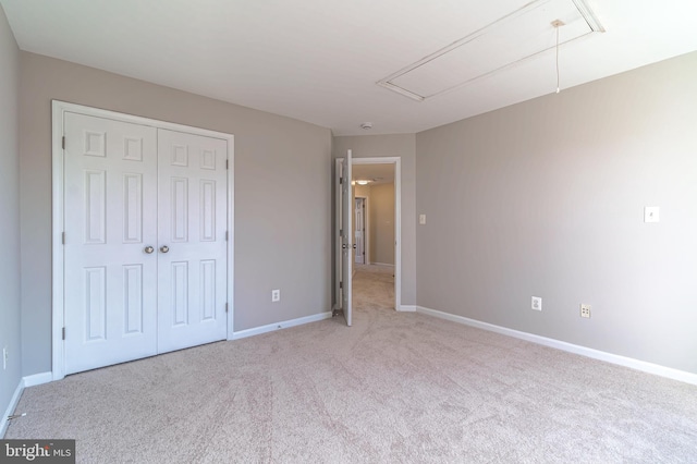 unfurnished bedroom featuring light colored carpet and a closet