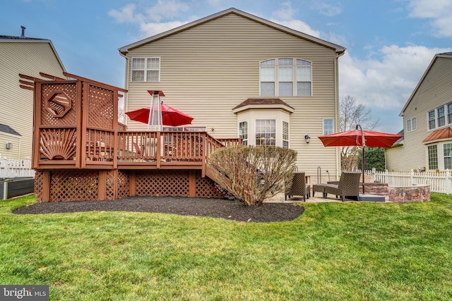 rear view of house featuring a yard and a deck