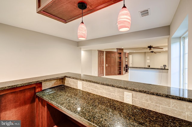 interior space featuring pendant lighting, ceiling fan, and dark stone counters