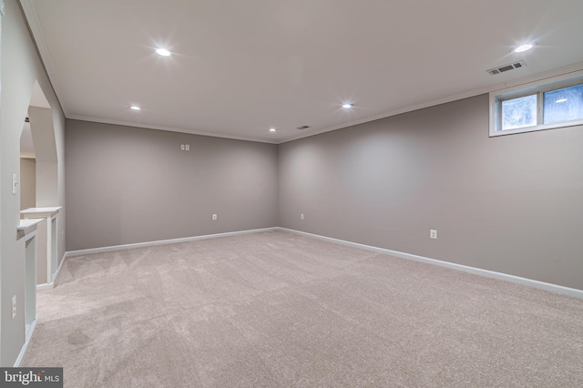 spare room featuring crown molding and light carpet