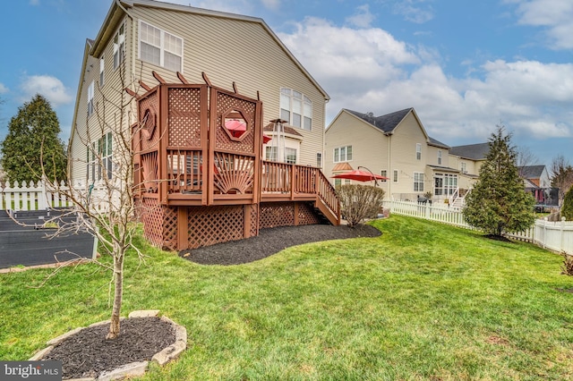 rear view of house featuring a deck and a lawn