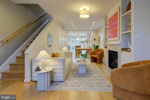 living room with light hardwood / wood-style flooring and a tile fireplace