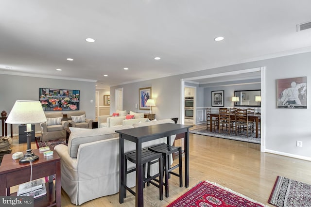 living room with ornamental molding and light wood-type flooring