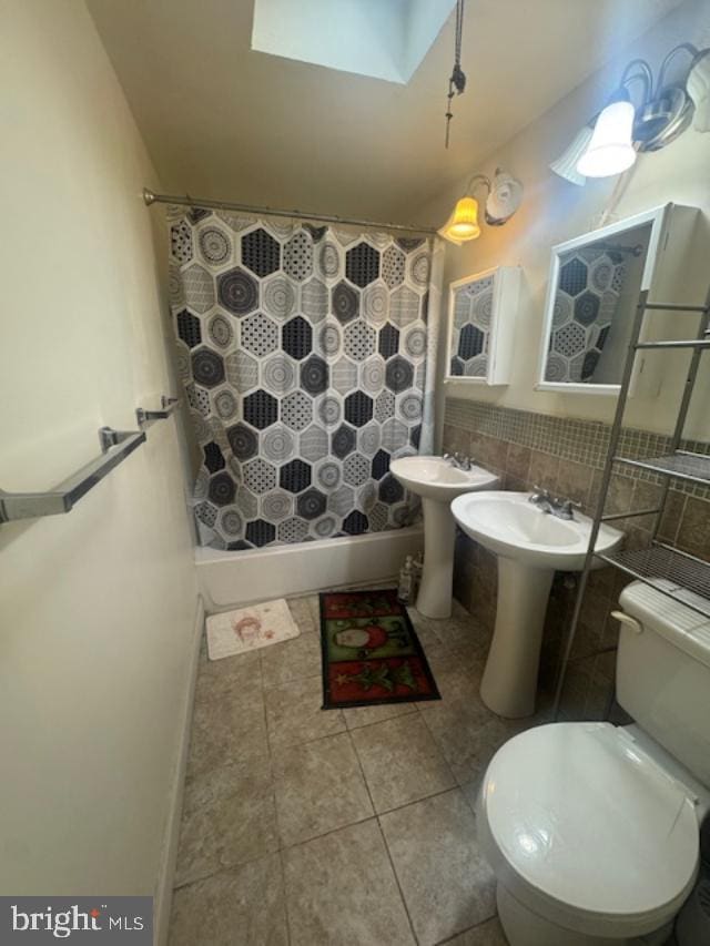 bathroom featuring tasteful backsplash, toilet, and a skylight