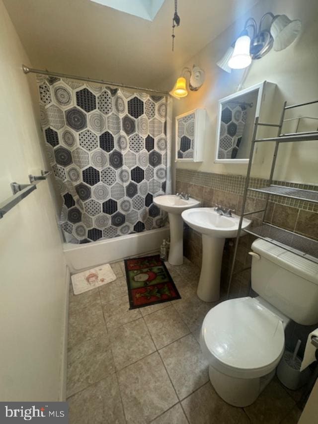 bathroom featuring a skylight, sink, backsplash, toilet, and a shower with curtain