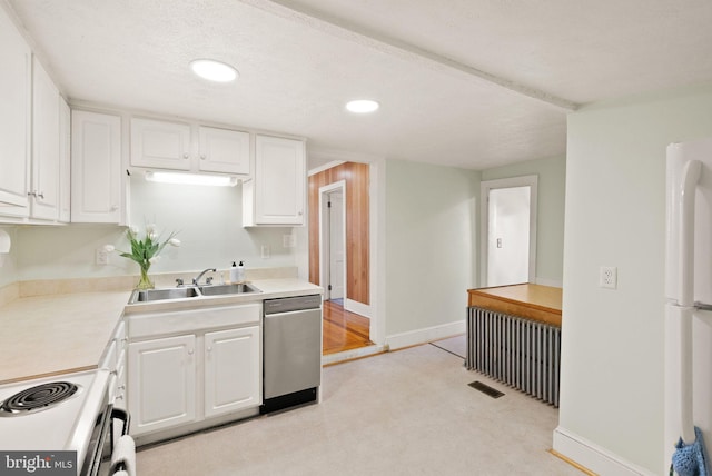 kitchen with sink, white appliances, radiator, and white cabinets