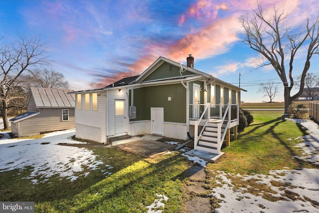 property exterior at dusk featuring a yard