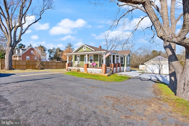 view of front of property featuring an outbuilding, a garage, and covered porch