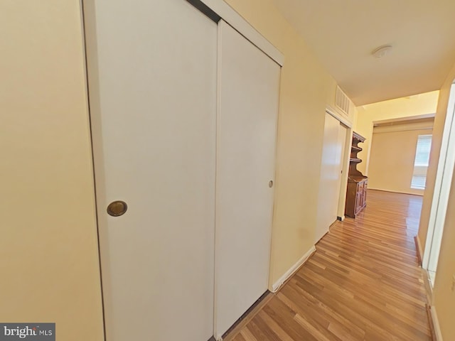 corridor with light hardwood / wood-style floors