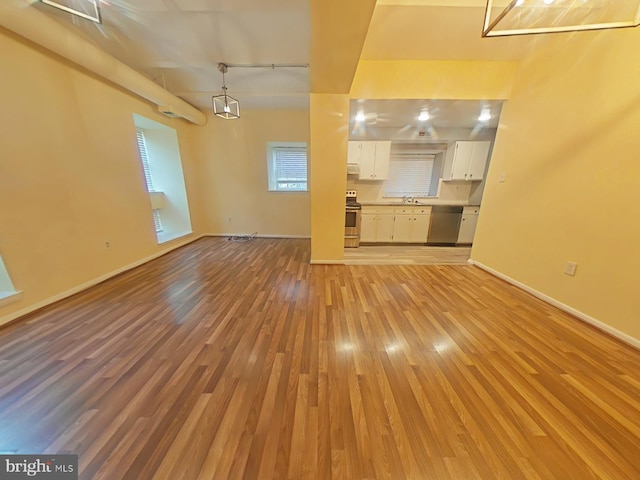 unfurnished living room with sink and light hardwood / wood-style flooring