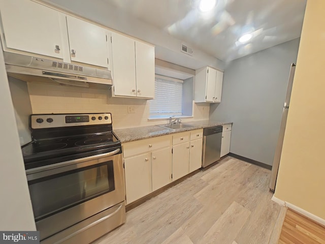 kitchen featuring white cabinetry, sink, light stone counters, stainless steel appliances, and light wood-type flooring