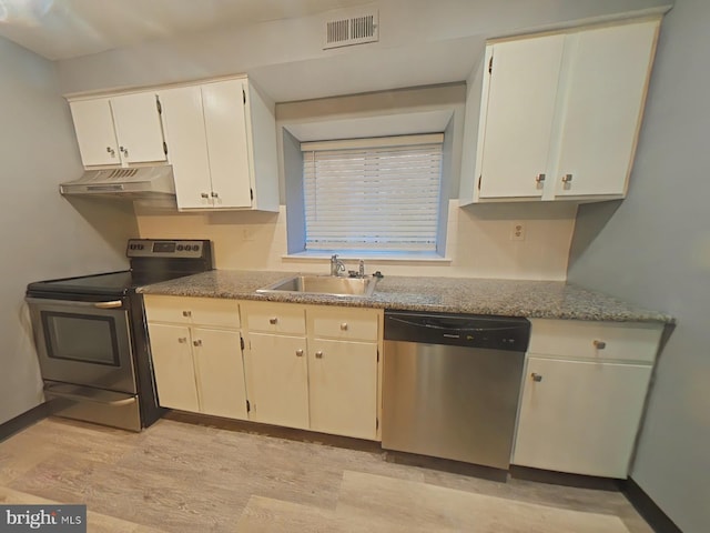 kitchen featuring sink, white cabinets, light stone counters, stainless steel appliances, and light hardwood / wood-style flooring