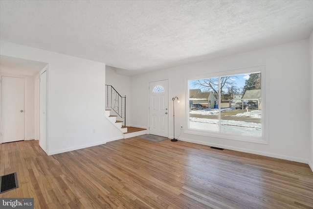 foyer entrance featuring hardwood / wood-style floors and a textured ceiling