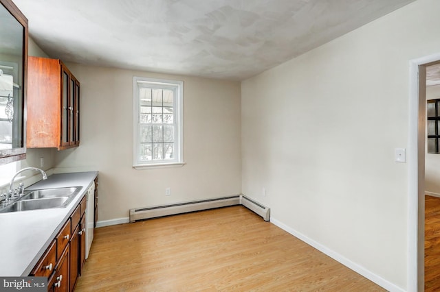 kitchen featuring a baseboard heating unit, sink, and light hardwood / wood-style flooring