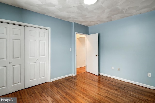 unfurnished bedroom featuring hardwood / wood-style flooring and a closet