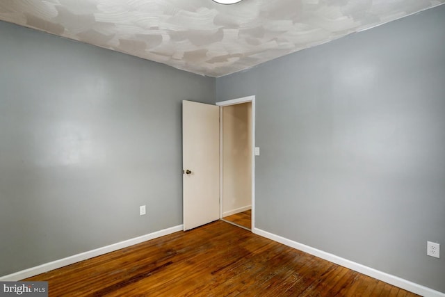 unfurnished room with dark hardwood / wood-style floors