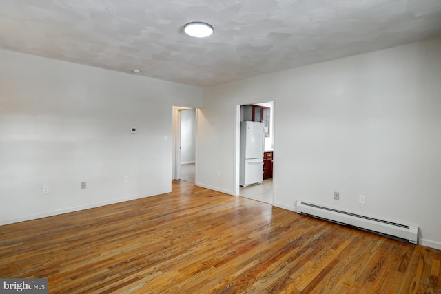 unfurnished room with light hardwood / wood-style flooring and a baseboard radiator