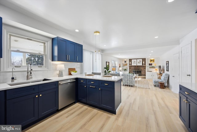 kitchen featuring sink, stainless steel dishwasher, light hardwood / wood-style floors, and kitchen peninsula