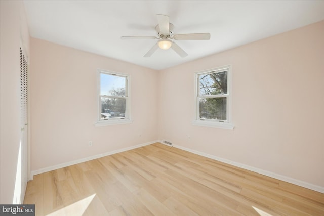 spare room with ceiling fan, plenty of natural light, and light hardwood / wood-style floors