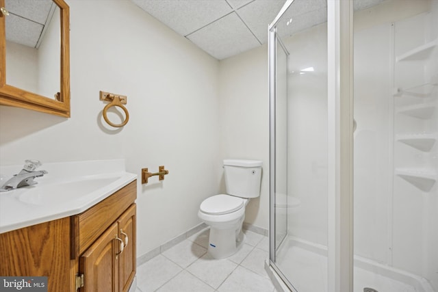 bathroom featuring a paneled ceiling, tile patterned flooring, an enclosed shower, vanity, and toilet