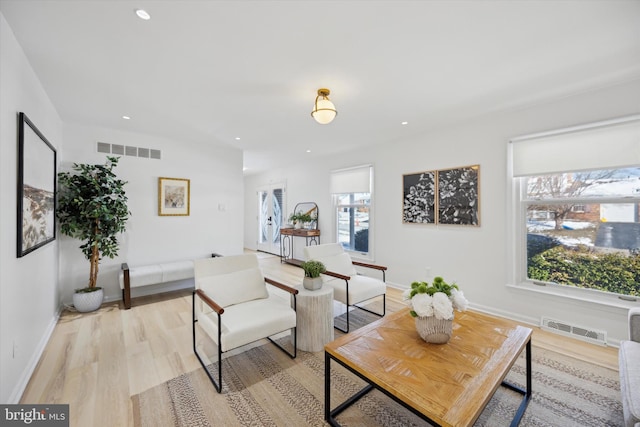 living room with a wealth of natural light and light hardwood / wood-style flooring