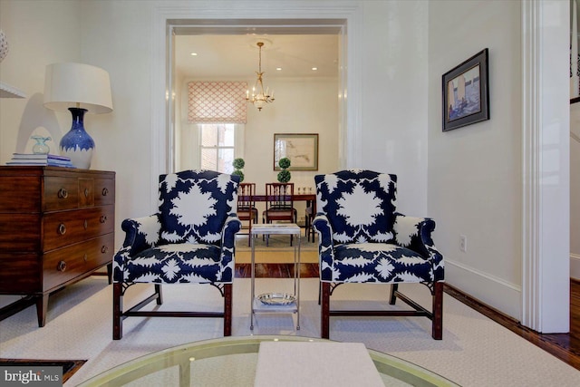 living area featuring baseboards and a notable chandelier