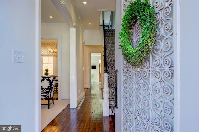 hallway with baseboards, recessed lighting, dark wood-style flooring, crown molding, and a chandelier